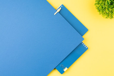 Spiral notepad with stationery on office table.