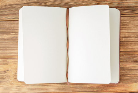 Open brown notebook on wooden background.の写真素材