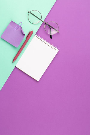 Spiral notepad with pen, note sheet and glasses.の写真素材