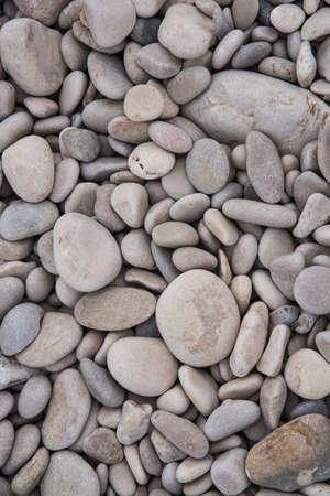 Closer top view of grey and brown beach stones background in Altea beach Spain. Nature background