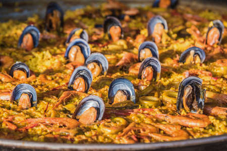 Typical spanish seafood paella in traditional pan close view. Selective focus.の写真素材