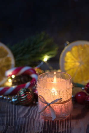 Close view Magic Christmas decorated Burning candle on wooden rustic background.の写真素材