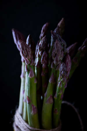Fresh green purple asparagus closeup on dark background. Gourmet concept. Selective focus.の写真素材