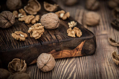 Close up view composition of walnut kernels and whole walnuts on rustic cuting desk. Selective focus. 4の写真素材