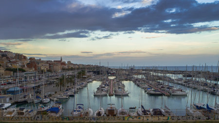 Aerial panoramic view on moored sailboats in Marina yacht club port of Montgat at sunset with dramatic cloudy sky, still calming water. Barcelona, Spain.の写真素材