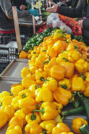 Fresh organic yellow bell paprika pepper on weekly spanish market. Food background close up shot with selective focus.の写真素材