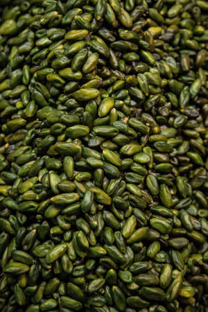 Flat lay photo of pistachio nuts without shells as food background. Fresh green pistachios as texture.の写真素材