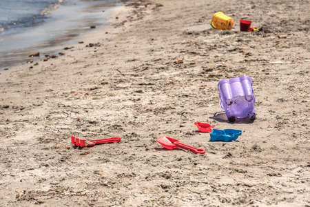 A child's losted plastic sand buckets raker and scoop at the beach. Sunny day on Mediterranean sea.の写真素材