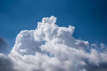 Beautiful fluffy white and dark clouds on the blue sky with sun beams. Hot summer day in Spain.の写真素材