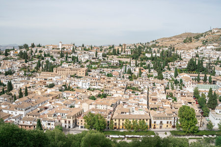 Detailed landscape photo of Albacin district, Granada old town, Andalusia, Spain 2019. White houses with tiled roofs surrounded by cypresses and other greenery.の写真素材
