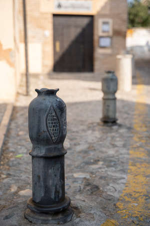 Cast iron black parking bollards in the form of pomegranates on street of Granada, Andalusia, Spainの写真素材