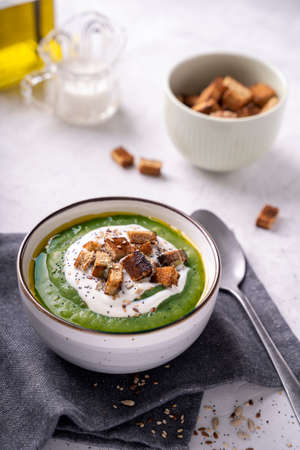 Rustic spinach and broccoli rich soup puree with cream croutons and seeds.の写真素材