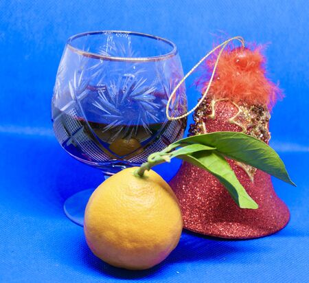 Still life-wine glass, Mandarin and bell on a blue background.のeditorial素材