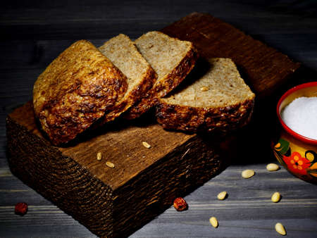 Slices of black, whole-grain bread on a wooden bar, on a black background, Close-up, Macro photo