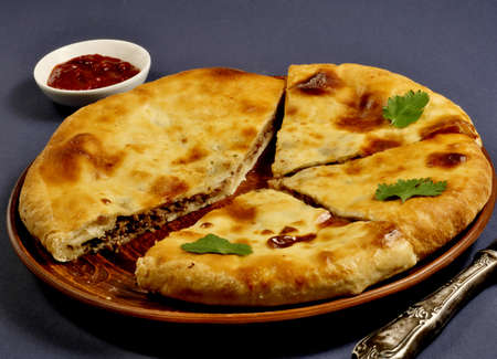 Khachapuri in Ossetian style-with tender Imereti cheese and juicy beef meat, spicy spices and finely...