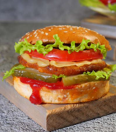 Burger, with cutlet and tomato with cheese on wooden boards, Close-up, Macrophotography, Rational nutrition, Proper dietの写真素材