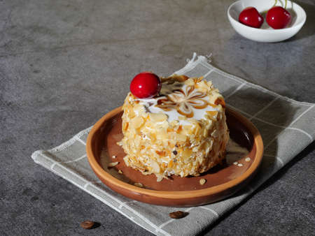 Cake with cherries and caramel on a plate on a gray backgroundの写真素材