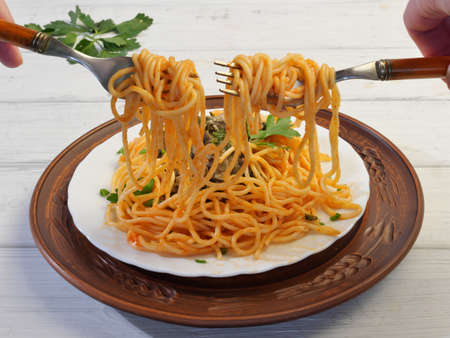 spaghetti with pesto sauce in a plate on a wooden tableの写真素材