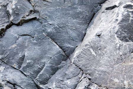 Uneven surface of gray monolithic stone with cracksの写真素材