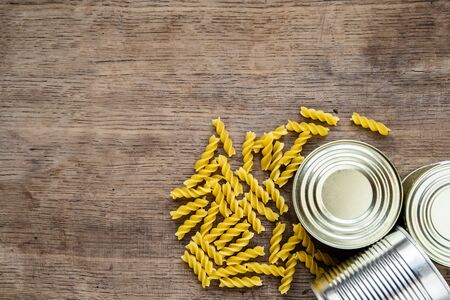 Food stock for coronavirus quarantine isolation period on wooden background. different food in aluminum cans, Rice, pasta. Food delivery, Donation. top view. Copy spaceの写真素材
