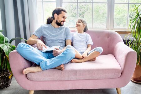 Father and little girl reading a book, laughing and enjoying at home. Happy parenthood. Father and daughter spending time together. Fathers day and happy family staying at home concept.の写真素材