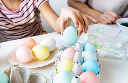 Close up girl takes colorful dyed easter eggs. Lifestyle Easter celebration handmade concept.の写真素材