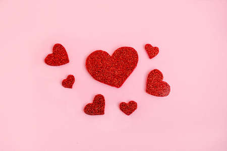 Love theme background with red glitter handmade hearts on pink background. Romantic conceptの写真素材