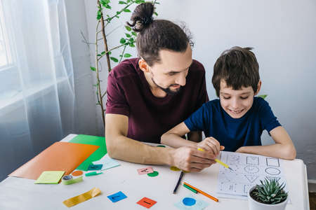 Autistic boy during therapy at home with his father with learning and having fun together. Autism awareness conceptの写真素材