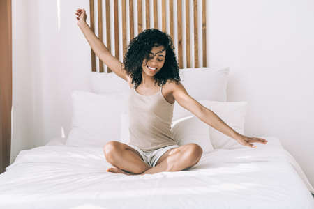 Woman waking up in bed at morningの写真素材