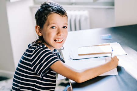 Autism boywrites in a notebook at home. Aspeger syndrome and autism invisible diseases lifestyleの写真素材