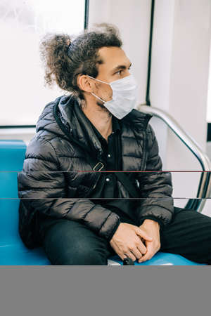 Social distancing to crowd while commuting in the Rome underground. Man wearing protective face mask...