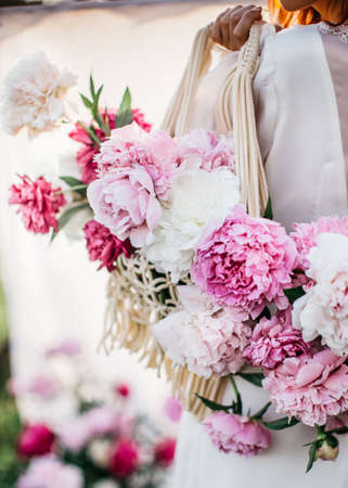 Summer romantic flowers concept. Close up portrait of woman in a white dress holding bouquet of...