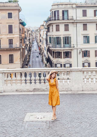 Young woman in orange outfit stay overlooking Rome. Spanish steps. Rome Italy concept.の写真素材