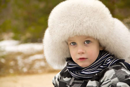 Cute boy in a cap with ear-flapsの写真素材