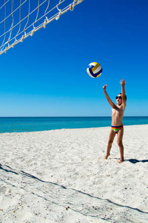 Kid play volleyball on sea beachの写真素材
