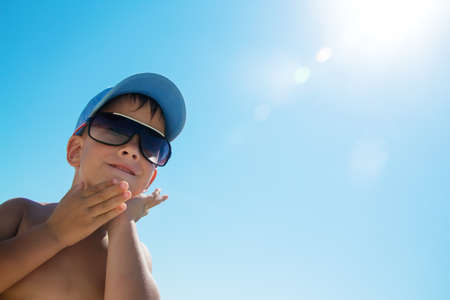 Beautiful child wearing blue cap on beach