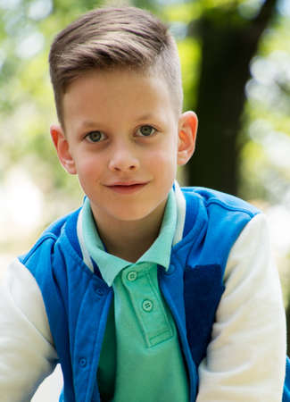 Charming casual kid with fashionable haircut in street