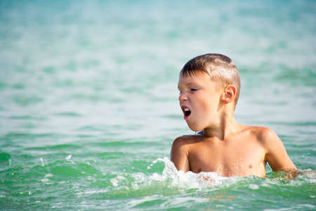 kid emerging from the sea waterの写真素材