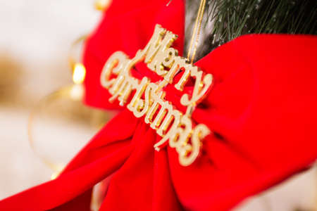 fir branches with red bow with sing Merry Christmas