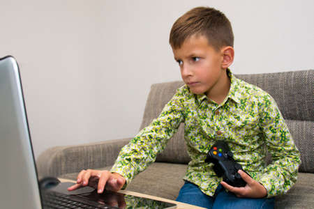 Cute boy playing video games at homeの写真素材