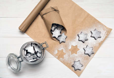 Choco cookies on craft paper on white wooden backgroundの写真素材