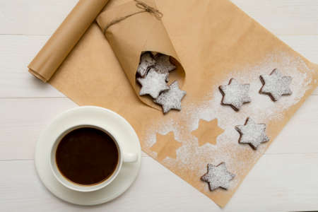 Coffe and choco cookies with sugar-powder and on white wooden backgroundの写真素材
