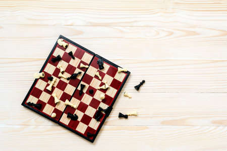 Chess board and some figures on the white woden background. End of the game. Top view. Space for textの写真素材