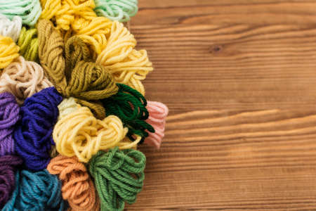 Colorful knitting threads on a wooden background.の写真素材