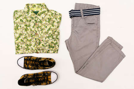 Top view fashion trendy look of kids clothes on white wooden background. Kids fashion. Spring, autumn outfit.の写真素材