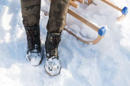 Men's or woomen's winter boots on snow. green warm winter boots closeup, Camouflage, military pants.の写真素材
