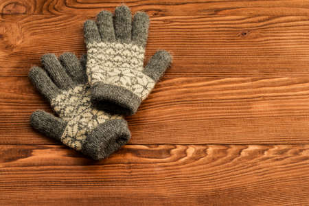 Grey gloves on old wooden background.の写真素材