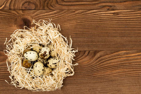 Quail eggs in a nest on a old wooden backgroundの写真素材