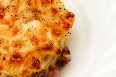 Delicious meat baked in oven with, cheese and pineapple on plate sprinkled with purple onion, view from aboveの写真素材