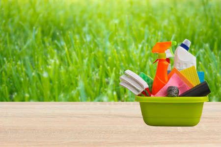 Spring cleaning concept with supplies against green nature blured backgroundの写真素材